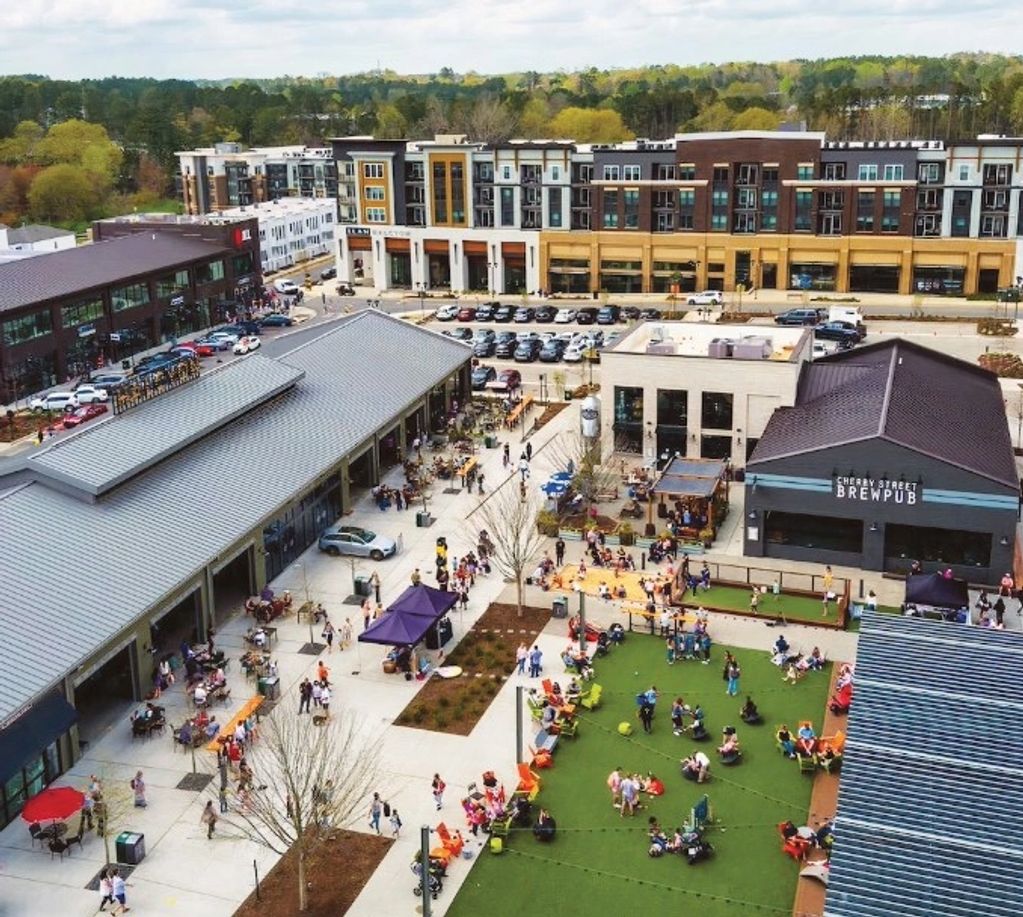 A lively outdoor urban plaza with people enjoying leisure activities and dining.
