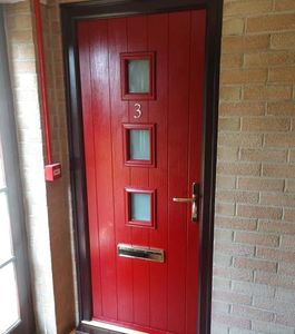 Certified FD30 Composite Fire Door in red with a black, brown frame and gold hardware.