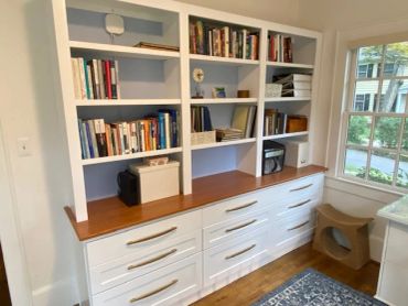 Bookshelf with drawers and books in a bright room.