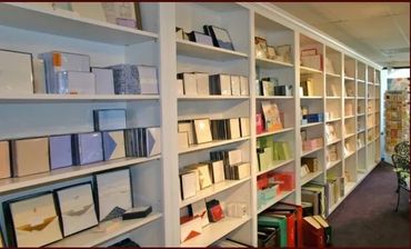 A long bookshelf filled with various books and albums in a well-lit room.
