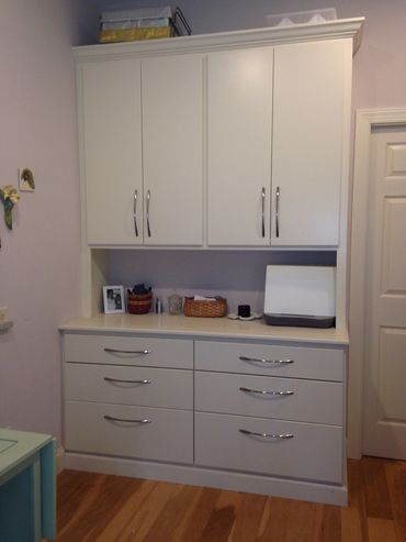 White kitchen cabinet with drawers and upper storage.