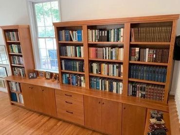 Wooden bookshelf filled with various books.