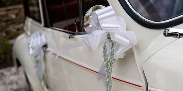 White decorative bows on a vintage car door handle.