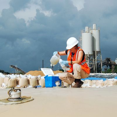 Sampling industrial wastewater accumulated in military fuel bladders for storage.