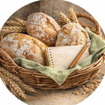 Rustic basket with fresh bread, wheat stalks, and a notebook with pencil.