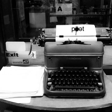 typewriter with poet logo on paper
