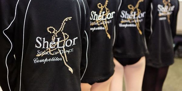 four people wearing ShéLor School of Dance t shirts 