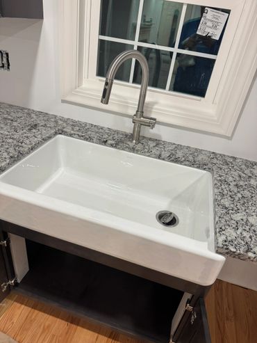 Modern farmhouse sink with granite countertop and sleek faucet.
