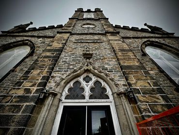 Low-angle view of a historic stone church facade with gothic windows.