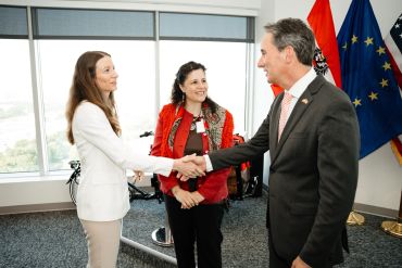 Two people shaking hands during a formal meeting.