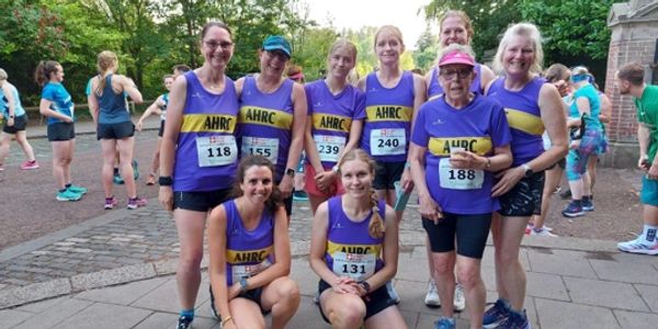 Group of women in AHRC running vests posing before a race.
