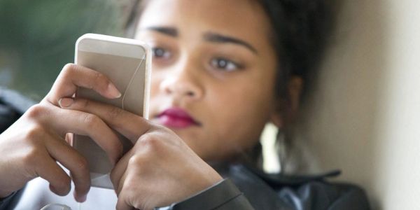 Young woman focused on her smartphone screen.