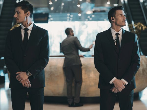 Two security guards dressed in costumes, guarding inside a mall