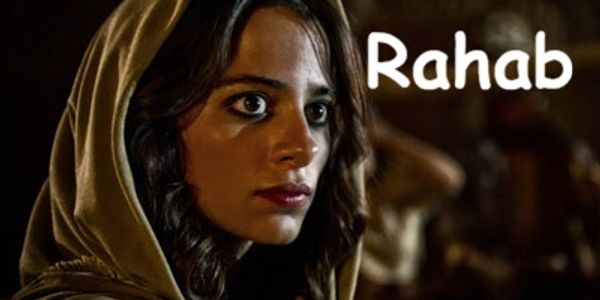 A woman named Rahab looking intently, wearing a hooded garment.