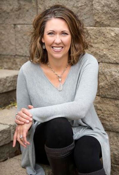 Woman sitting on stone steps, smiling.