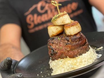 10oz filet topped with seared scallops over mushroom risotto at Cody Steakhouse