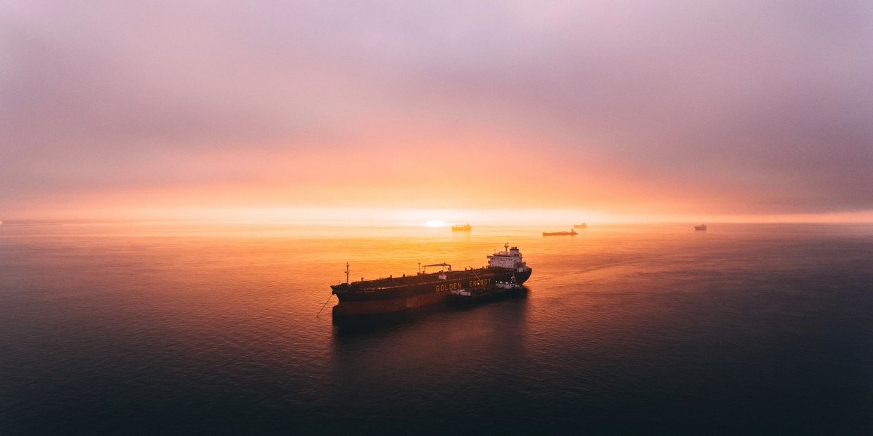 Boat on the horizon with a red and orange sunset