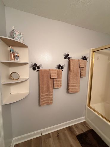 Bathroom with brown towels and corner shelf.