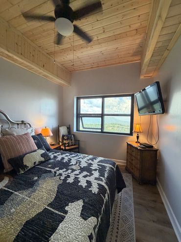 Cozy bedroom with nature-themed bedding and window view.