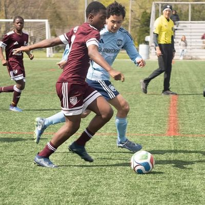 Youth soccer players competing intensely for the ball on the field.