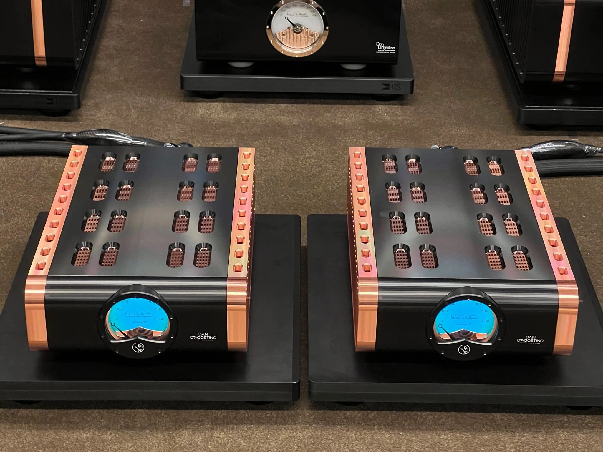 High-end Dan D'Agostino audio amplifiers with copper accents and blue meters.