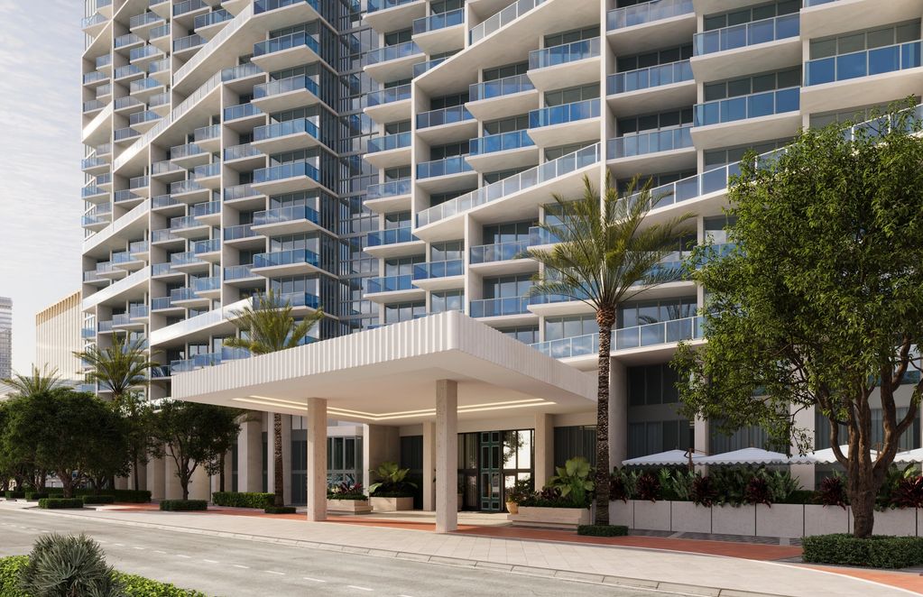 Modern high-rise apartment building with balconies and an entrance canopy.