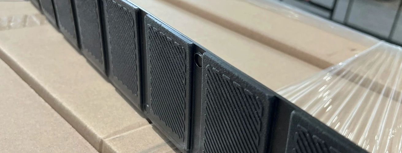 Close-up of black plastic clips arranged on cardboard packaging.