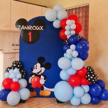Mickey Mouse-themed balloon decoration for a first birthday party.