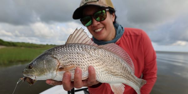 Person holding a large fish on a boat.