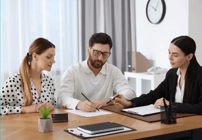 
a notary assisting a couple finalize their estate planning documents.