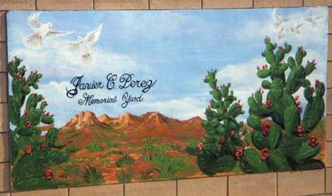 Outdoor wall mural painted on block wall in back yard. memorial with mexico desert, cacti, doves