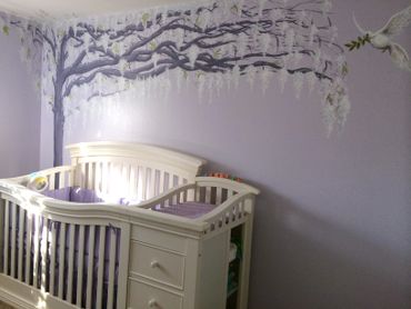 Purple wall painted mural with white wisteria hanging from dark purple tree over white baby crib. 