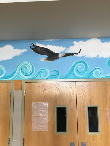 Flying eagle blue sky with white clouds and stylized aqua ocean waves painted mural Menifee, CA