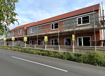New houses under construction with scaffolding and roofing in progress.