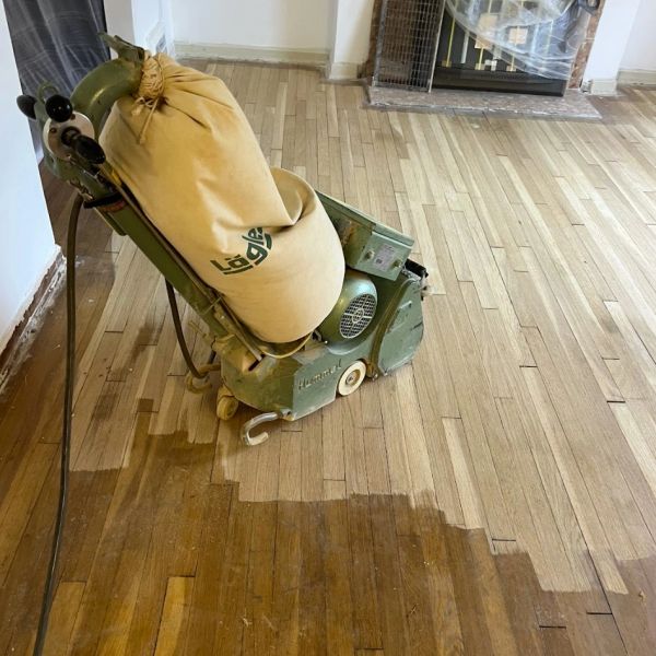 Sanding wood floors in Parma, Ohio. Professional drum sander removing old finish.