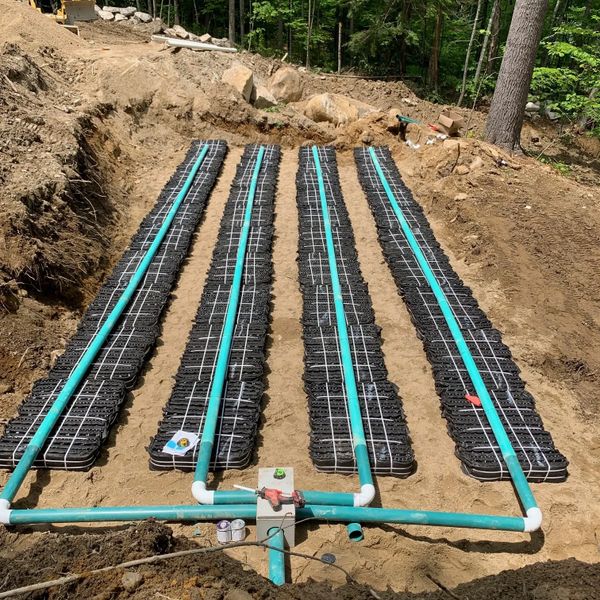 Sewer lines being installed for a septic system and sand mound.
