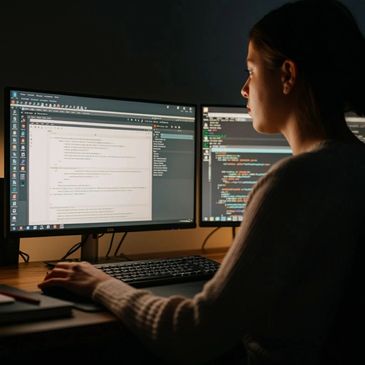 Person sitting in front of computers writing documentation.