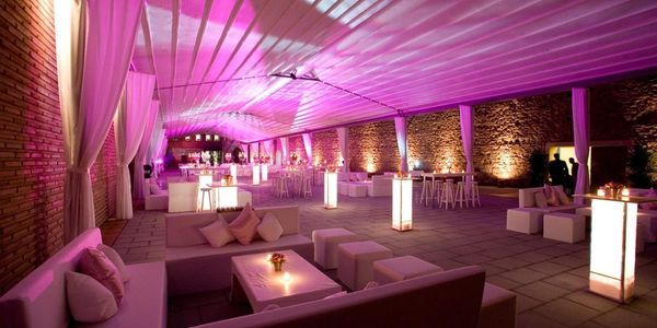 Ambient pink-lit rooftop lounge with retractable roof and modern soft seating.