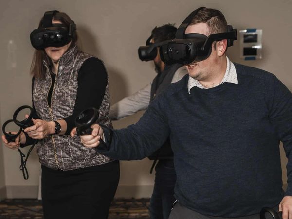Corporate group playing free roam vr game for team building