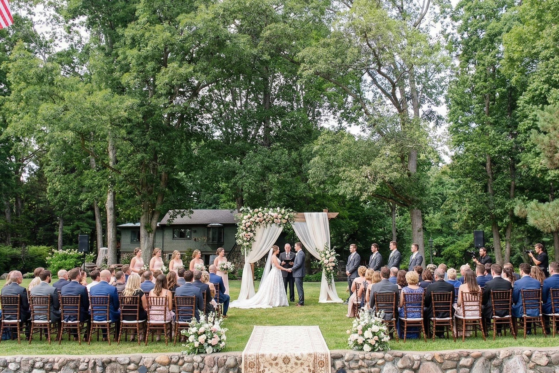 A group of people witnessing a couple get married at Jack Frost Museum near the Stonewall Cottage.