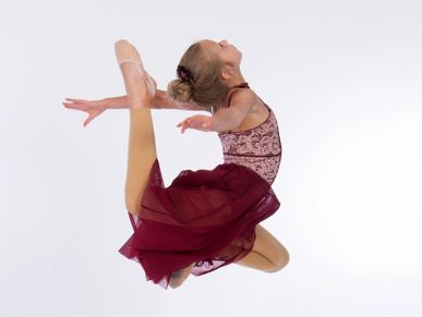 Young dancer performing a graceful leap in mid-air.
