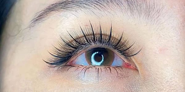 Close-up of an eye with long, curled eyelash extensions.