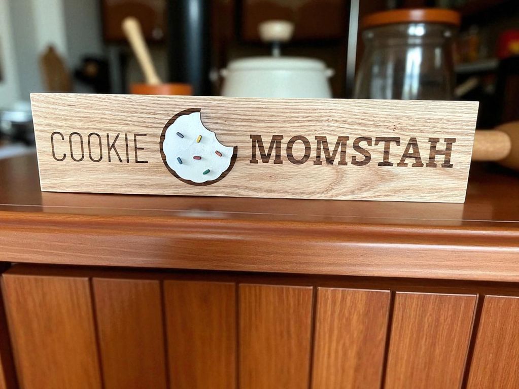 A rectangular sign with a cookie on it for a local business.