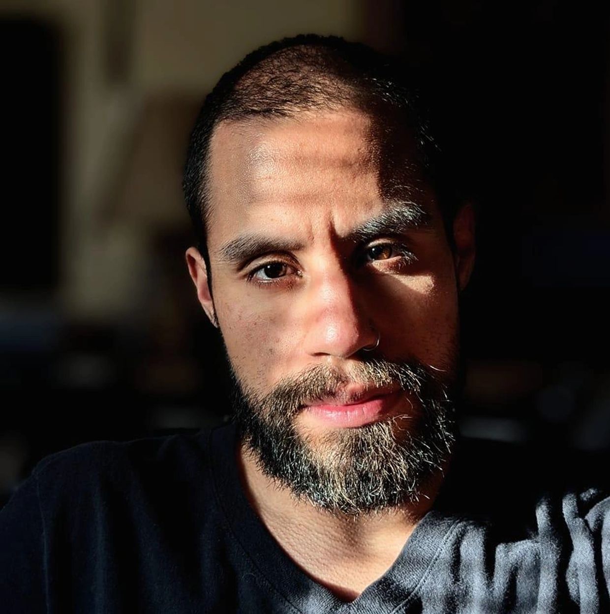 brown eyed balding bearded handsome man staring intensely  