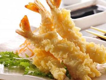 Crispy tempura shrimp served with dipping sauce and greens.
