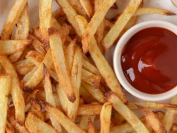 Crispy French fries served with a side of ketchup.