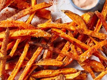 Crispy sweet potato fries with a dipping sauce.