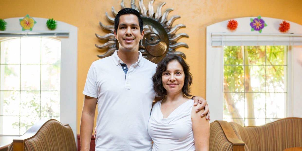 a couple in white outfit posing for a picture 