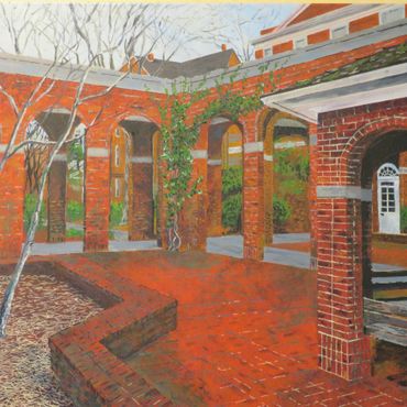 A brick courtyard with arches and greenery on a sunny day.
