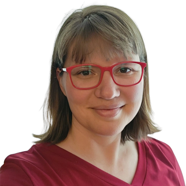 Smiling woman with short hair and red glasses wearing a red top.